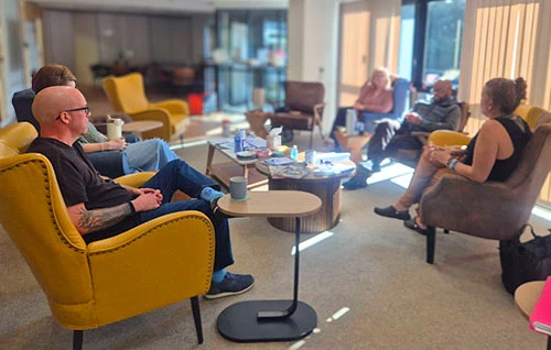 Members of Headway Shropshire’s Neuro Wellbeing Support Group sitting together and talking in a relaxed group setting.
